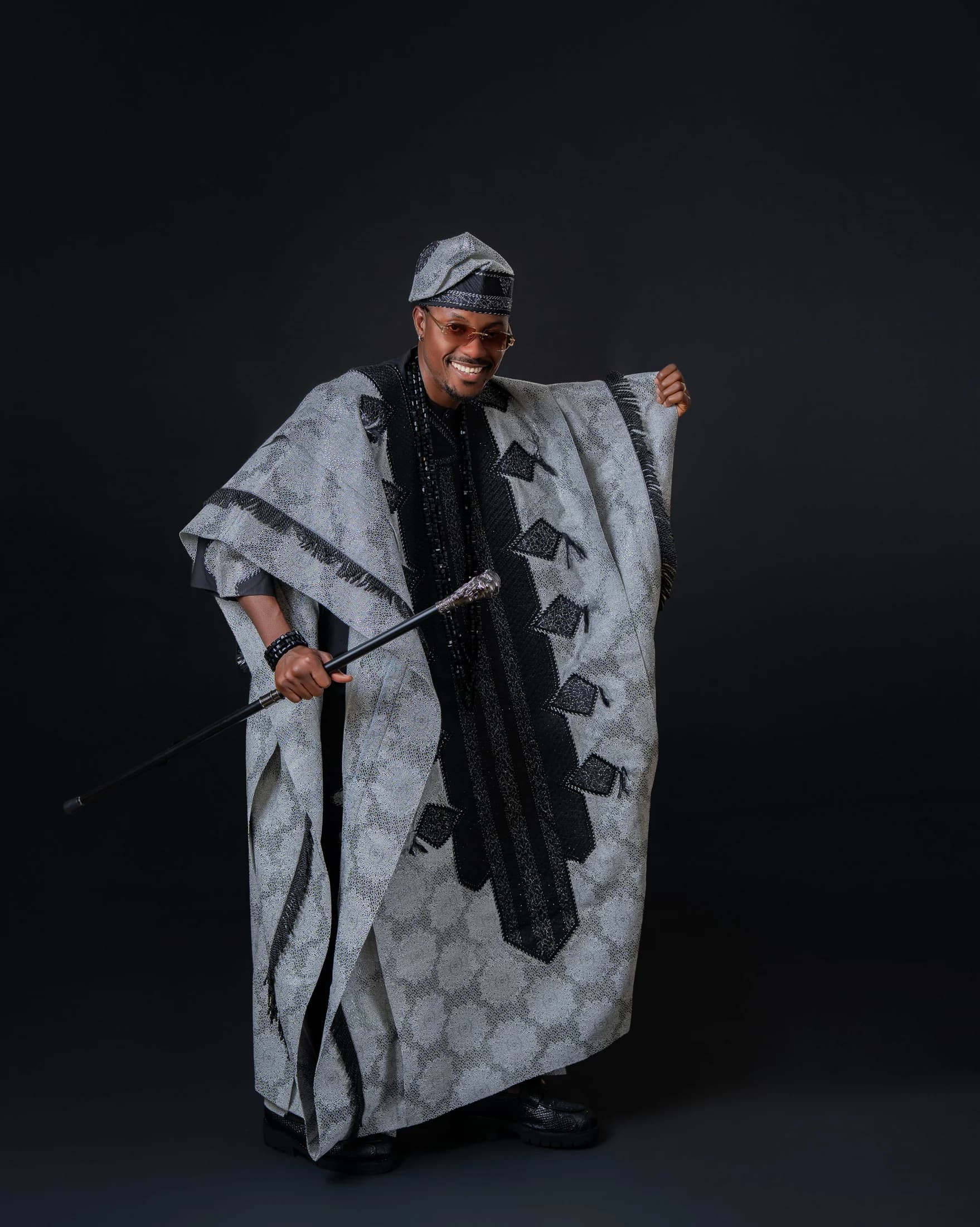 Philip Akinjobi smiling in black-and-silver Yoruba attire at forty