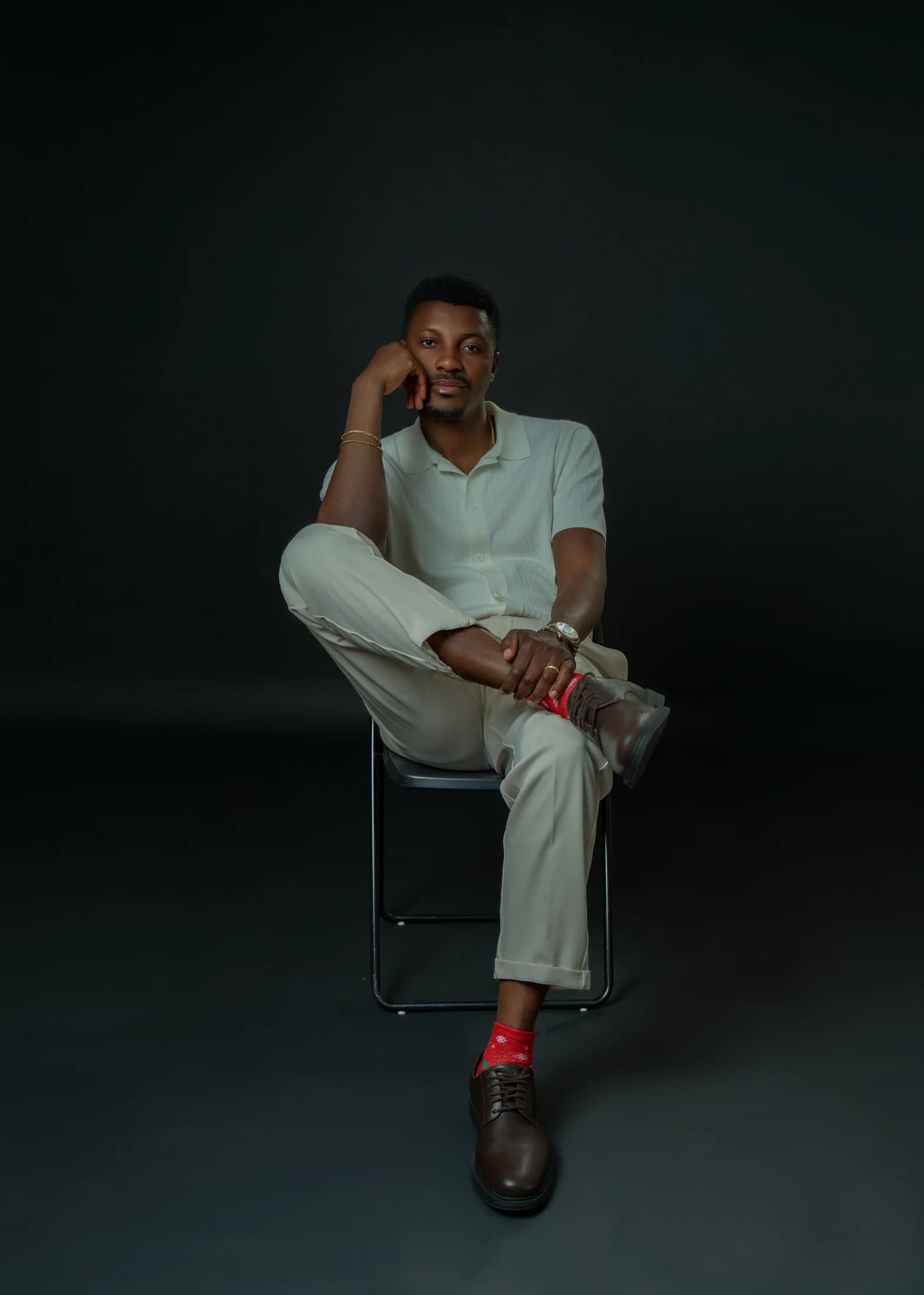 Philip Akinjobi seated thoughtfully with his chin resting on one hand
